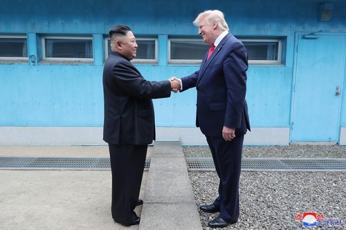 Donald Trump og Kim Jong-un takast í hendur. Mynd: EPA