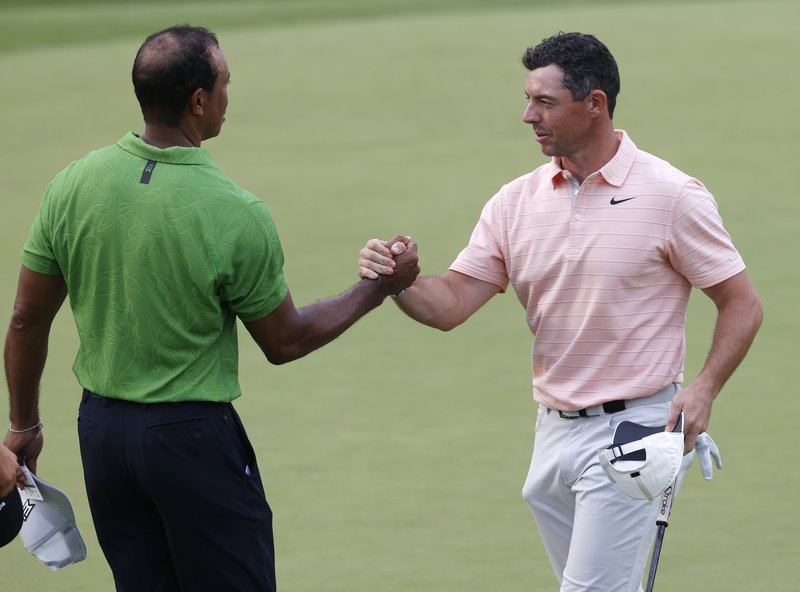 Tiger Woods og Rory McIlroy takast í hendur að loknum hring á PGA meistaramótinu sem fram fór í maí á þessu ári. Hvorugur þeirra hefur áhuga á að taka þátt á LIV mótaröðinni eins og sakir standa. Mynd: EPA